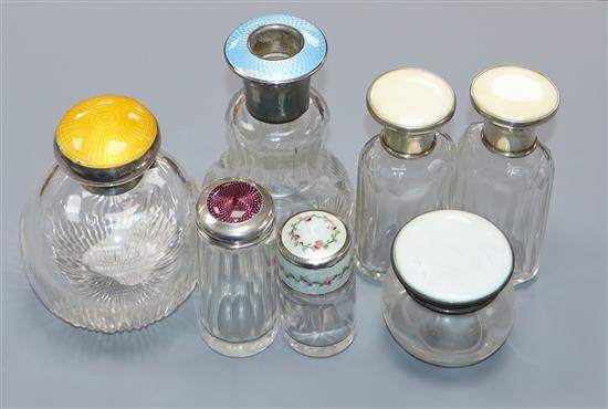 Seven assorted early 20th century silver mounted glass scent bottles including four with enamel, largest 11.2cm.